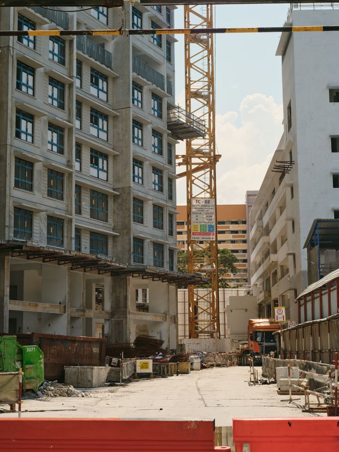 Crafting Captivating Headlines: Your awesome post title goes here A bustling urban construction site with a tower crane and surrounding buildings under a clear sky.